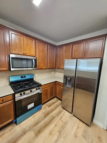 a kitchen with granite countertop a refrigerator stove and microwave