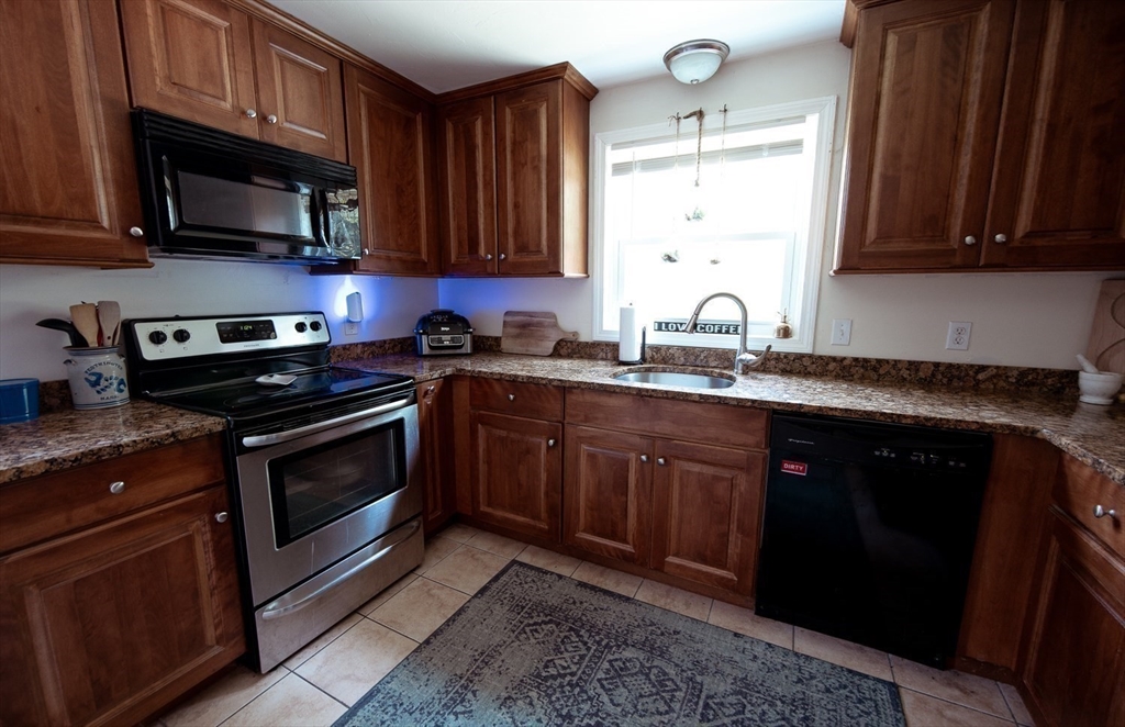 1124 Bemis Road, Unit A Warren, MA 01585 - Photo 15 of 33 a kitchen with stainless steel appliances granite countertop a sink a stove a microwave oven and cabinets