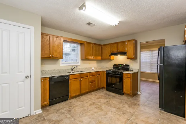 a kitchen with stainless steel appliances granite countertop a stove sink and refrigerator