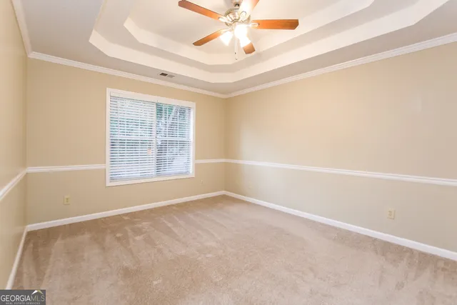 an empty room with a window and a ceiling fan