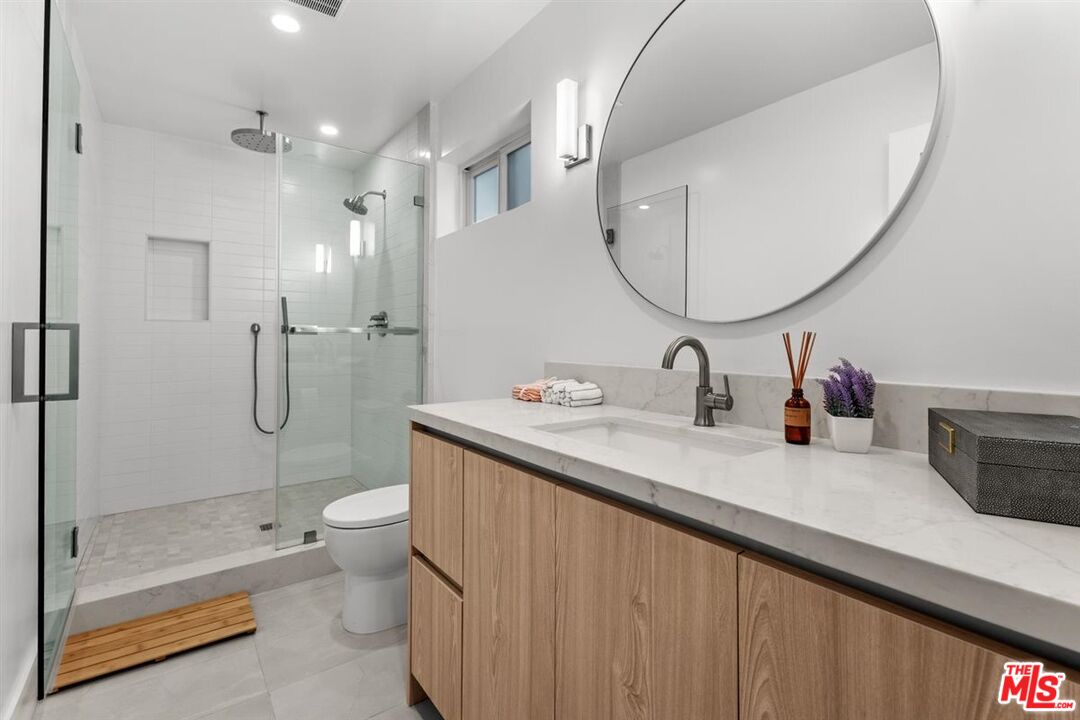 1573 Hi Point Street Los Angeles, CA 90035 - Photo 35 of 56 a bathroom with a double vanity sink toilet and shower
