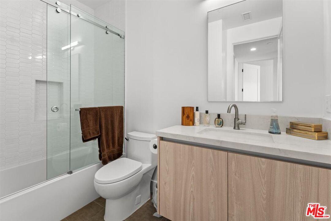 1573 Hi Point Street Los Angeles, CA 90035 - Photo 46 of 56 a bathroom with a granite countertop sink toilet and shower