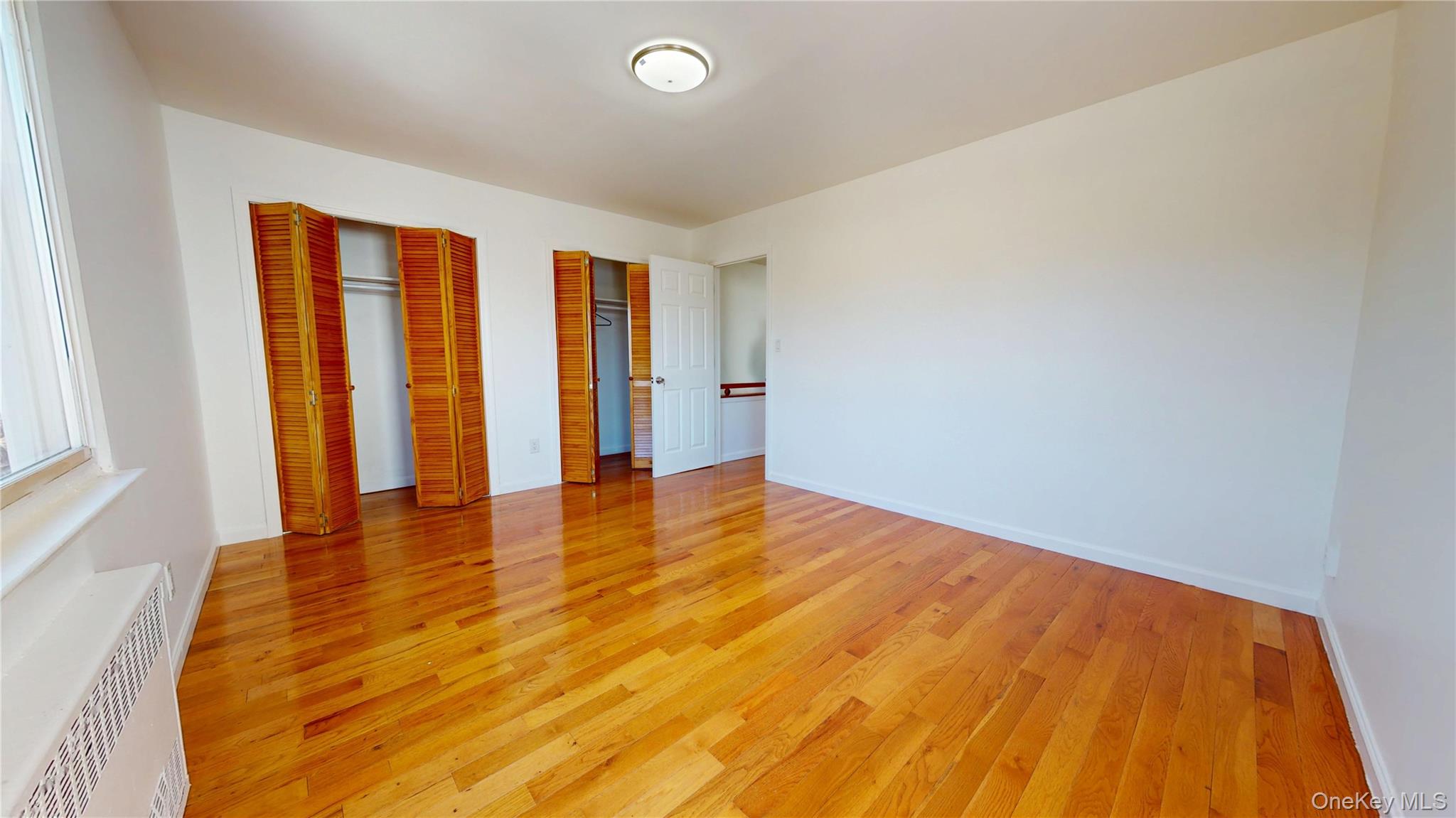 219-42 141st Road Queens, NY 11413 - Photo 18 of 23 a view of an empty room with wooden floor and a window