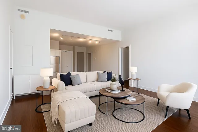 a living room with furniture and a wooden floor