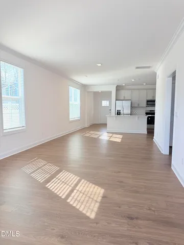 a view of empty room with wooden floor and window
