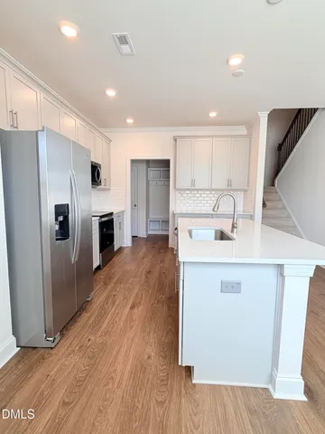 a kitchen with kitchen island a sink stainless steel appliances and cabinets