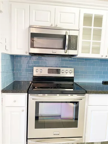 a stove top oven sitting inside of a kitchen