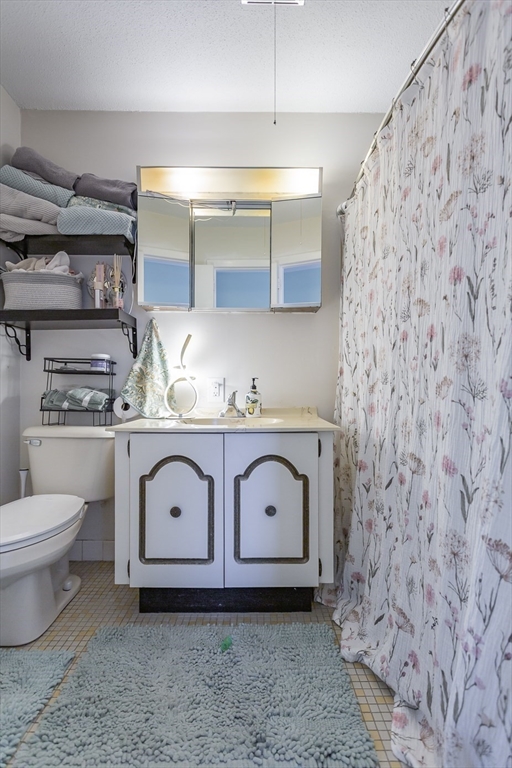 4700 North Main Street, Unit 1K Fall River, MA 02720 - Photo 11 of 18 a bathroom with a granite countertop sink and a toilet