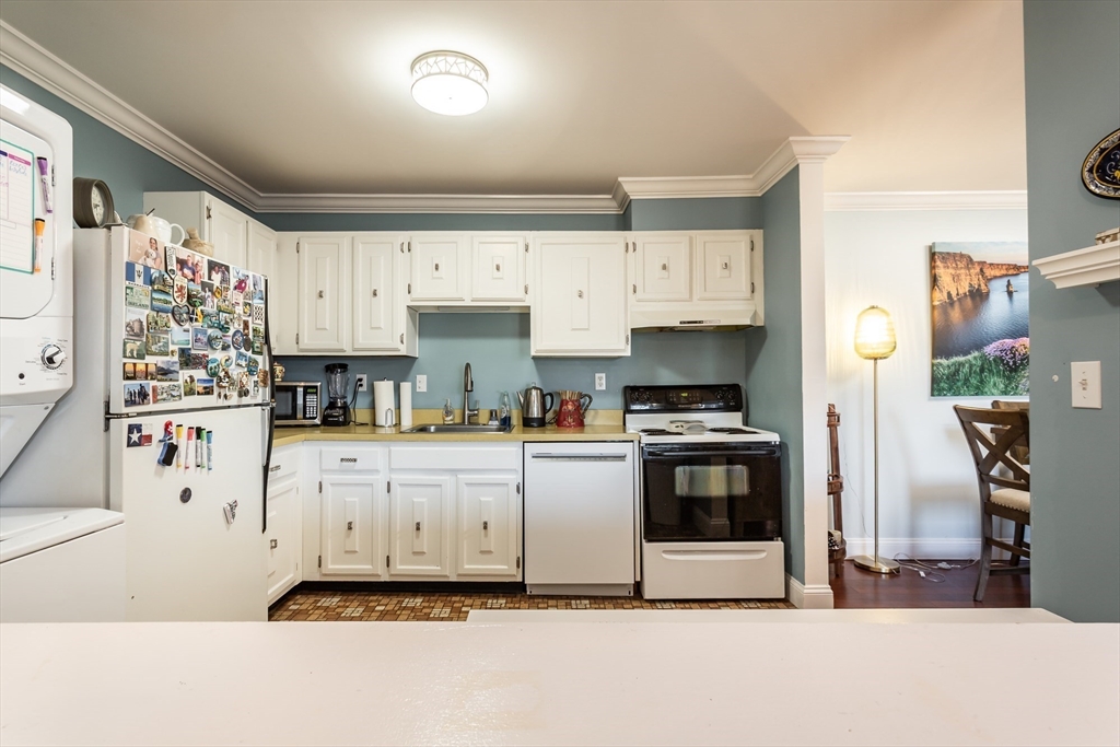 4700 North Main Street, Unit 1K Fall River, MA 02720 - Photo 7 of 18 a kitchen with stainless steel appliances a stove a refrigerator and white cabinets