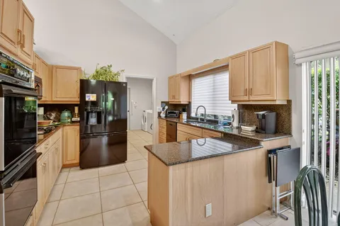 a kitchen with stainless steel appliances granite countertop a stove a sink and a refrigerator