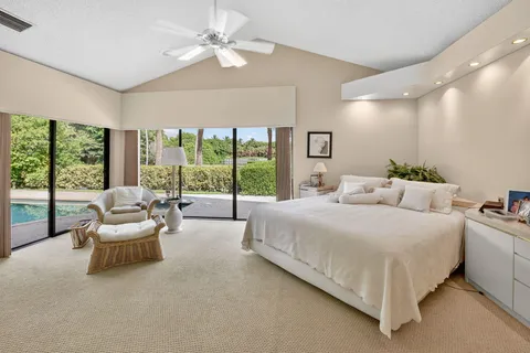 a bedroom with a bed couch and large window