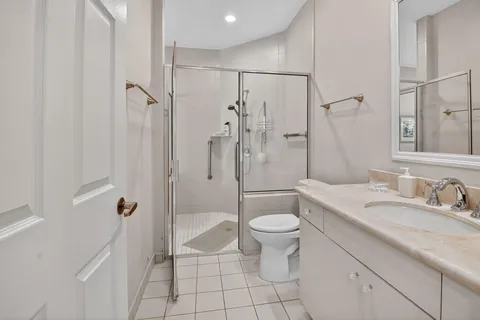 a bathroom with a granite countertop sink a toilet and shower