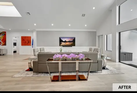 a living room with furniture a flat screen tv and a kitchen view