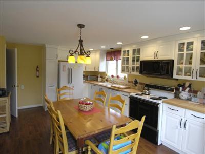 223 Rock Harbor Road, Unit D Orleans, MA 02653 - Photo 3 of 8 a dining room with furniture a chandelier and kitchen view
