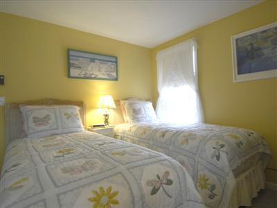 223 Rock Harbor Road, Unit D Orleans, MA 02653 - Photo 6 of 8 a bedroom with a bed and a painting on the wall