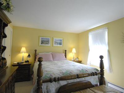 223 Rock Harbor Road, Unit D Orleans, MA 02653 - Photo 7 of 8 a bedroom with a bed and wooden floor