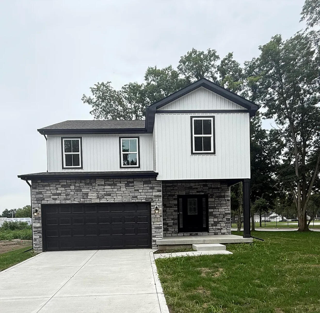 a front view of a house with yard and trees
