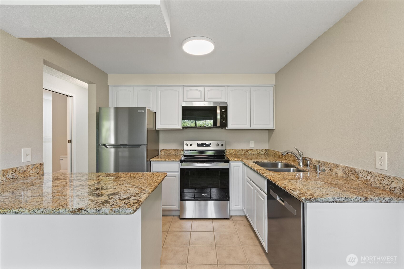 7700 196th Street Southwest, Unit C Edmonds, WA 98036 - Photo 14 of 26 a kitchen with a stove and a refrigerator
