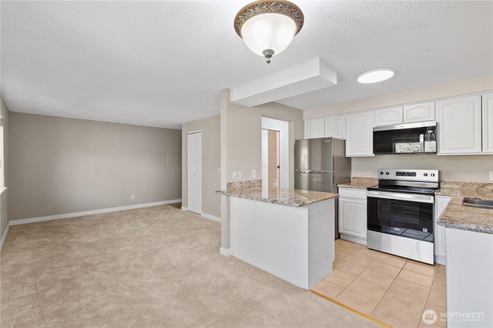 7700 196th Street Southwest, Unit C Edmonds, WA 98036 - Photo 10 of 26 a kitchen with stainless steel appliances granite countertop a stove cabinets and refrigerator