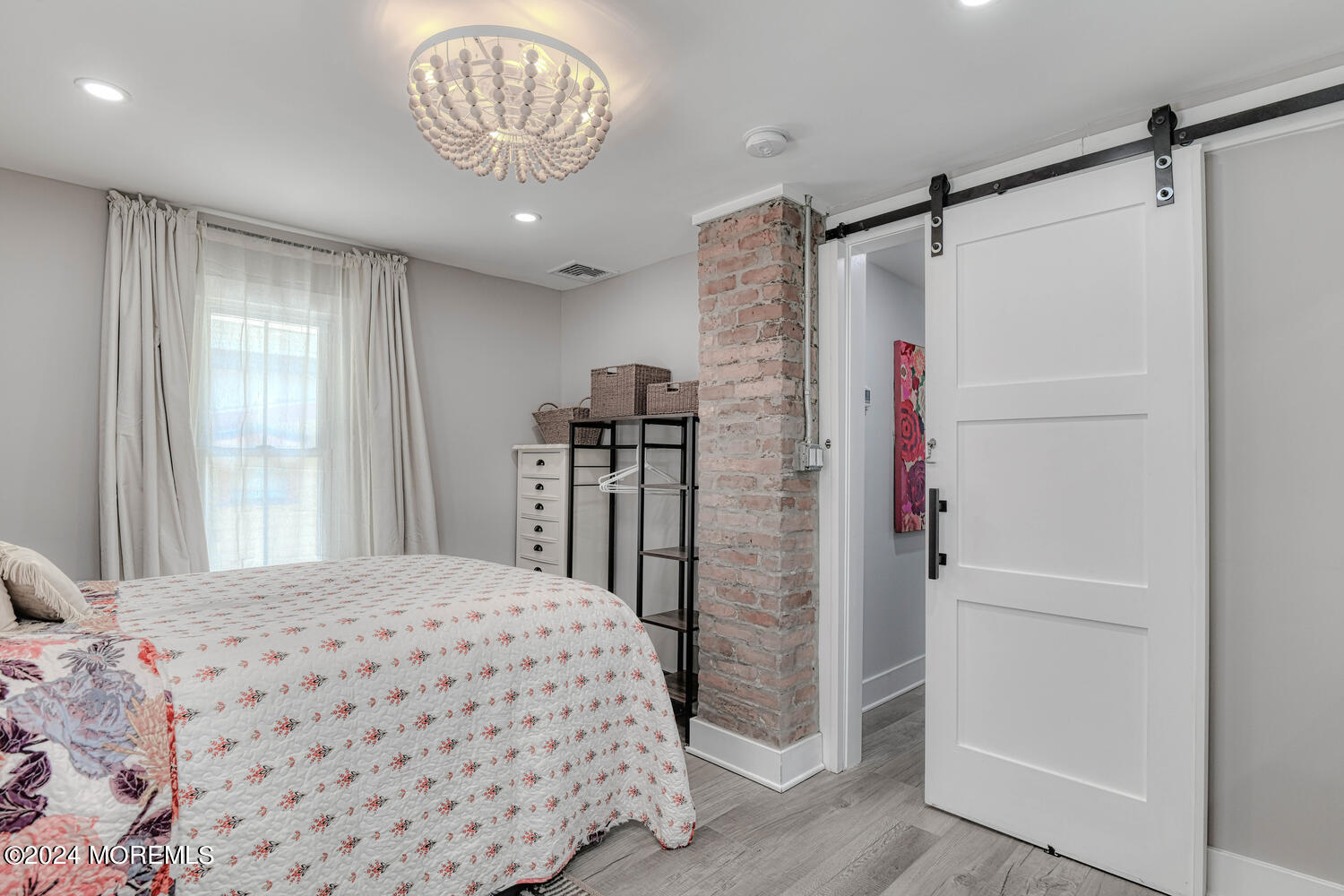 83 Broadway Ocean Grove, NJ 07756 - Photo 35 of 37 a bedroom with a bed and a chandelier