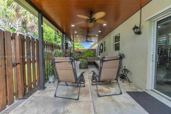 a view of a porch with chairs and potted plants