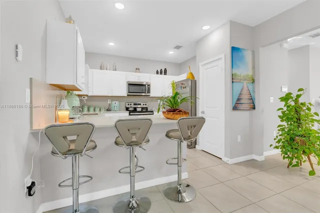 a kitchen with stainless steel appliances granite countertop white cabinets a sink and a stove