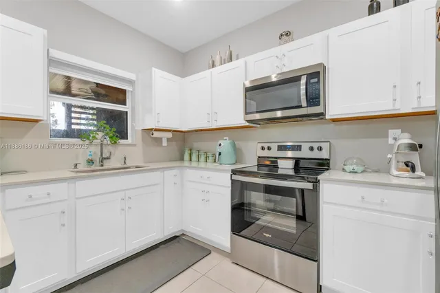 a kitchen with refrigerator a microwave a stove and cabinets