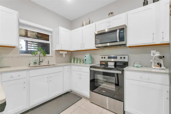 a kitchen with refrigerator a microwave a stove and cabinets