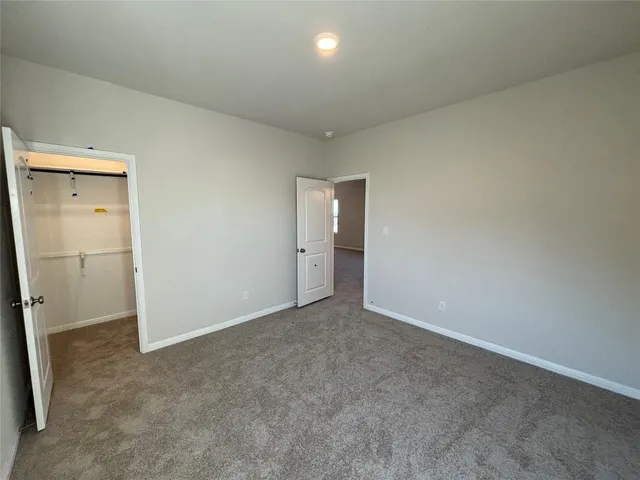 an empty room with closet and mirror