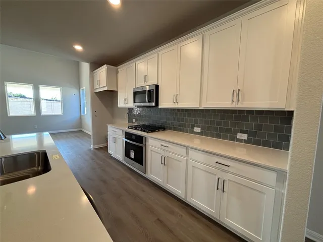 a view of a livingroom with wooden floor and stairs