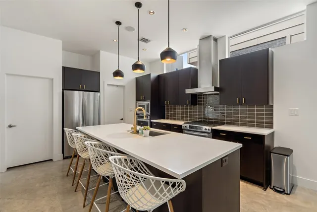 a kitchen with a sink a refrigerator a stove and a kitchen island
