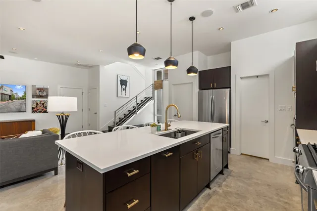 a kitchen with a stove a refrigerator a sink dishwasher with a dining table and chairs with wooden floor