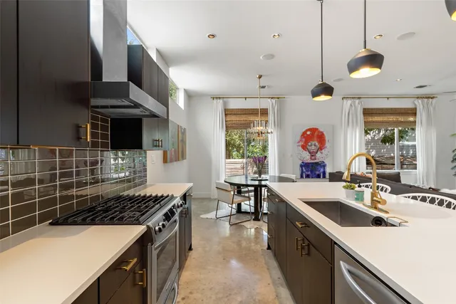 a kitchen with a sink a stove and chairs