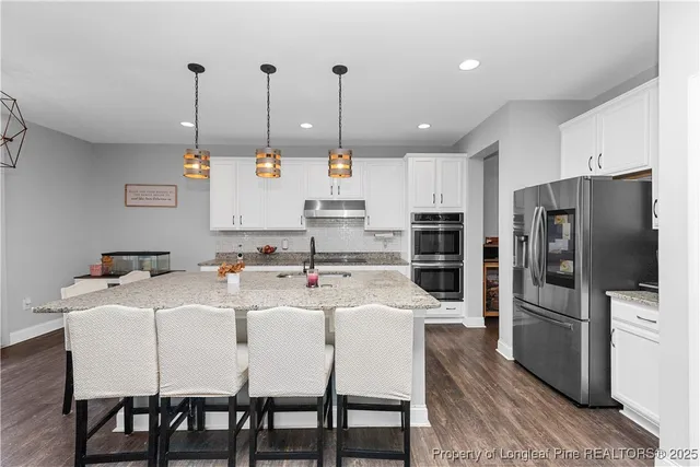 a kitchen with appliances a sink and a refrigerator