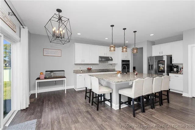 a kitchen with stainless steel appliances granite countertop a sink a oven and a granite counter tops