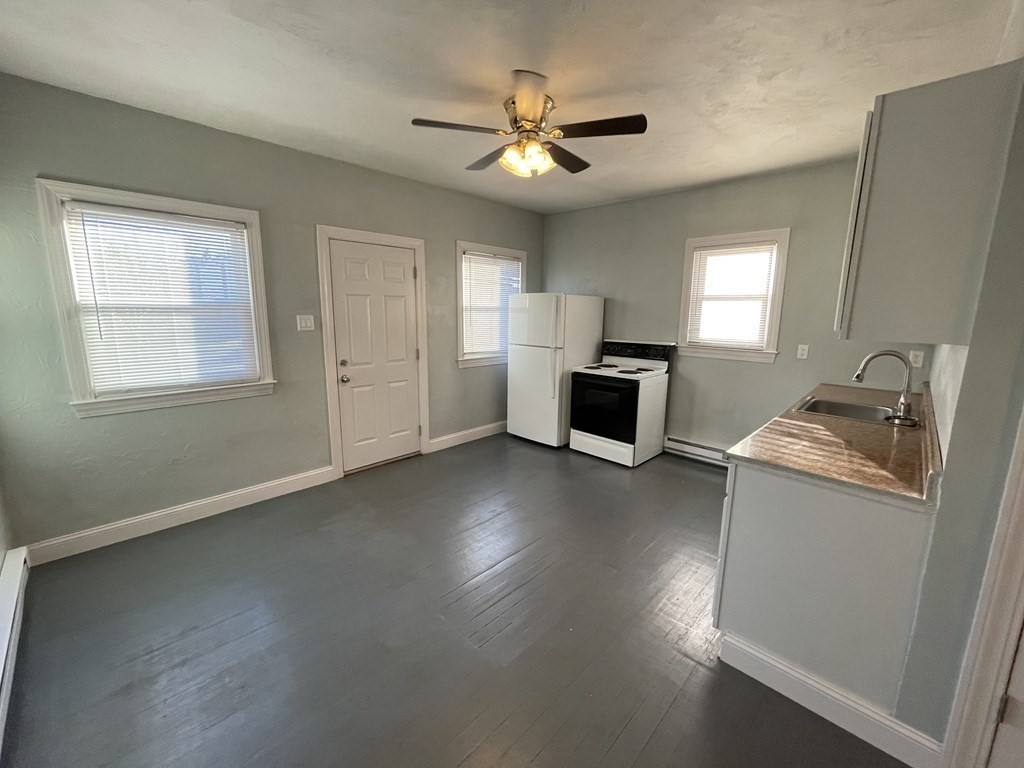 14 Hartford Avenue West, Unit 3 Uxbridge, MA 01569 - Photo 3 of 9 a workspace with wooden floor a ceiling fan and a window