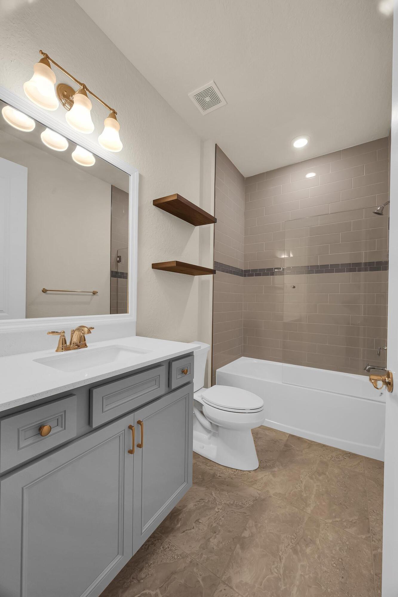 680 Southeast Villandry Way Port St. Lucie, FL 34984 - Photo 13 of 38 a bathroom with a sink a toilet and a mirror