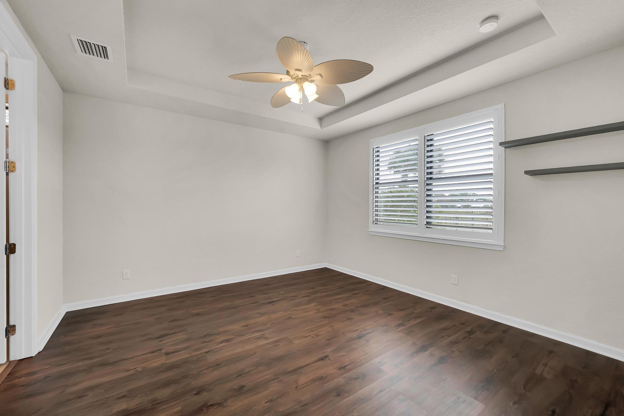 680 Southeast Villandry Way Port St. Lucie, FL 34984 - Photo 15 of 38 wooden floor in an empty room with a window