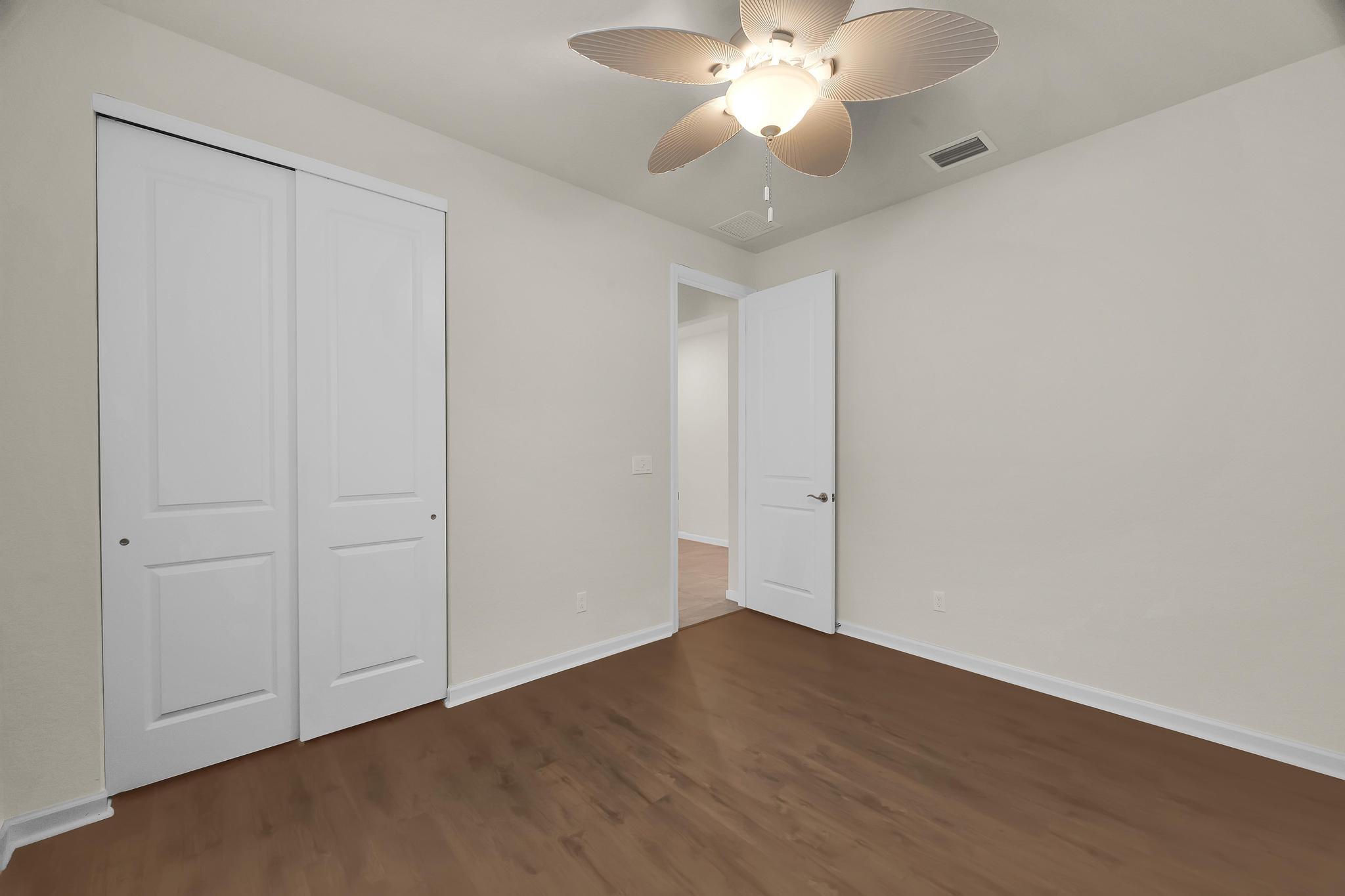 680 Southeast Villandry Way Port St. Lucie, FL 34984 - Photo 19 of 38 an empty room with wooden floor and fan