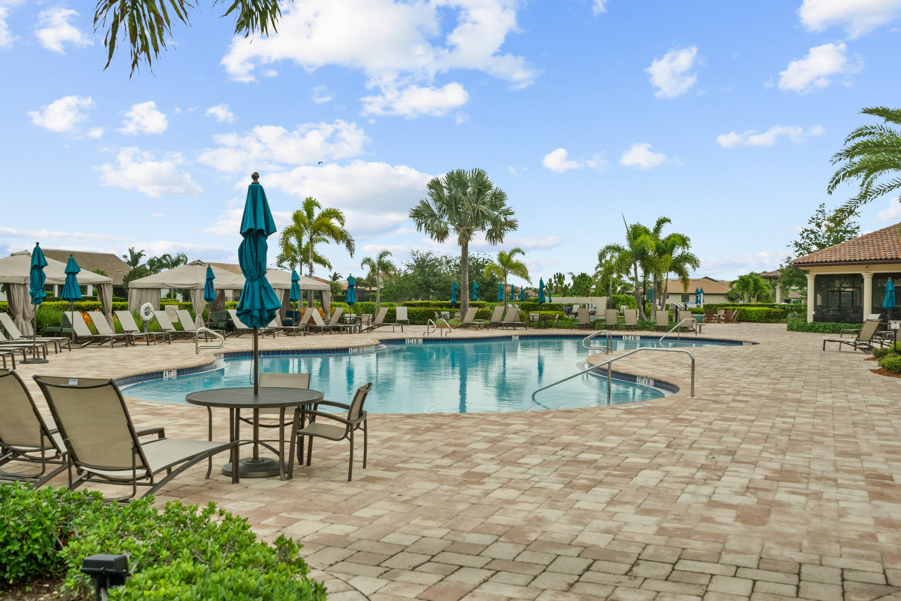 680 Southeast Villandry Way Port St. Lucie, FL 34984 - Photo 37 of 38 a view of a lake with a bench and trees in the background
