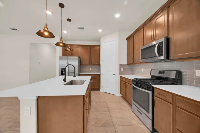 a kitchen with stainless steel appliances granite countertop a sink a stove and cabinets