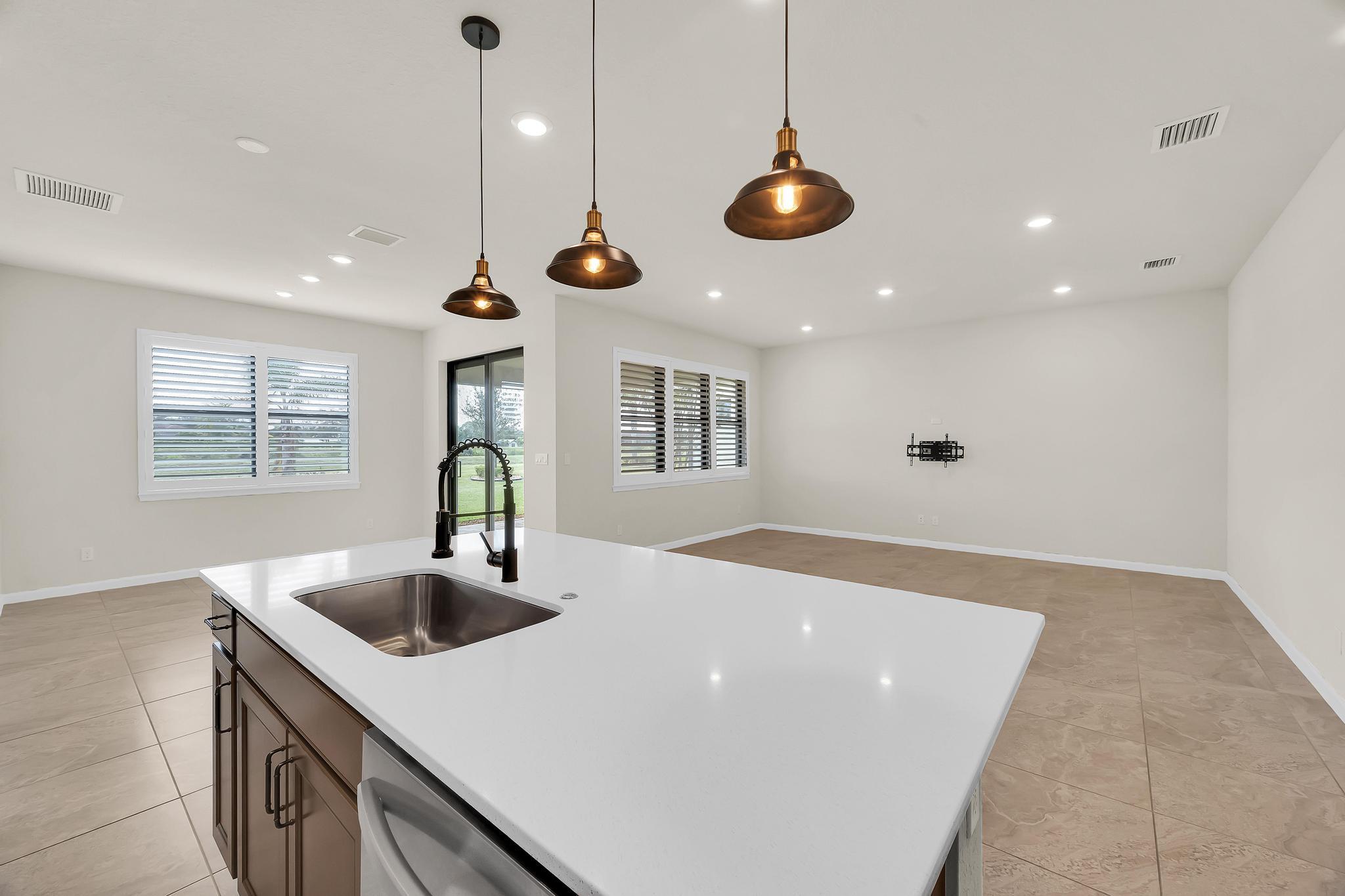 680 Southeast Villandry Way Port St. Lucie, FL 34984 - Photo 6 of 38 a kitchen with stainless steel appliances granite countertop a sink and a window