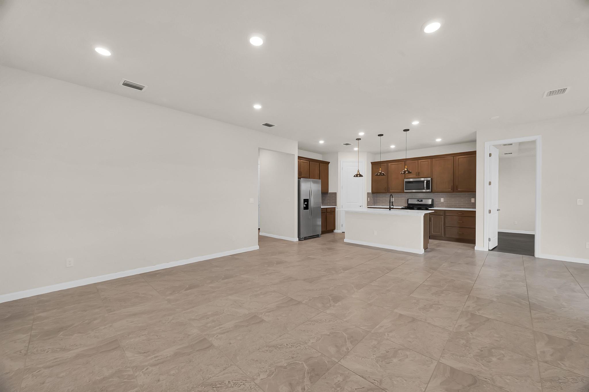 680 Southeast Villandry Way Port St. Lucie, FL 34984 - Photo 7 of 38 a view of a kitchen with a sink and a refrigerator in a kitchen