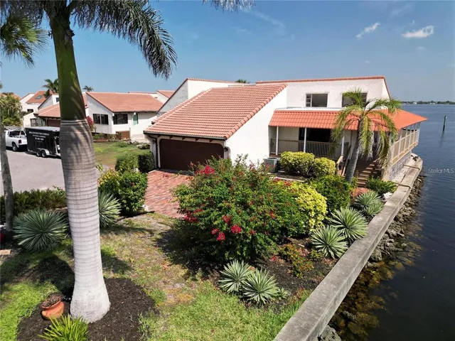 a front view of a house with a yard and potted plants