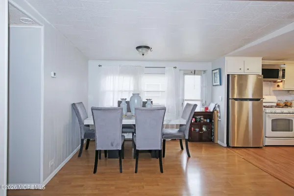 a view of a dining room with furniture and a refrigerator