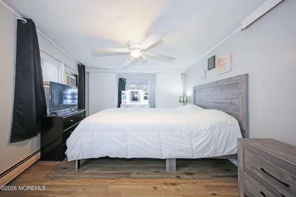 a bedroom with a bed and a flat tv screen on dresser