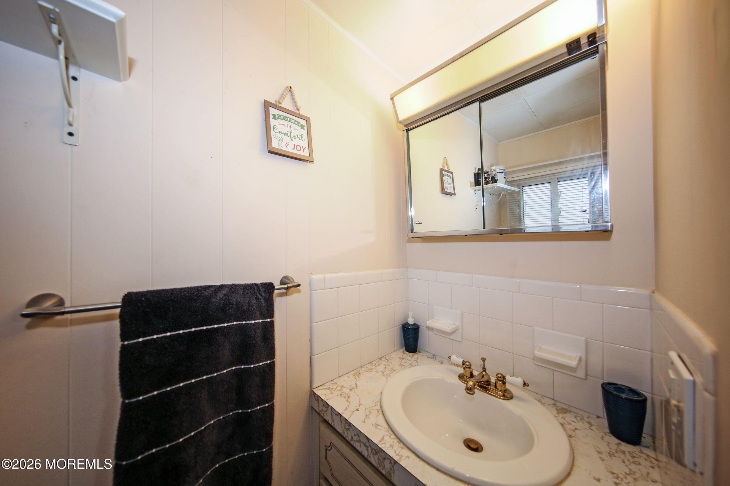 14 Monique Circle Hazlet, NJ 07730 - Photo 22 of 23 a bathroom with a sink and a mirror