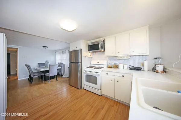 a kitchen with granite countertop a sink appliances cabinets and counter space