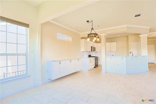 a large kitchen with cabinets and a large window