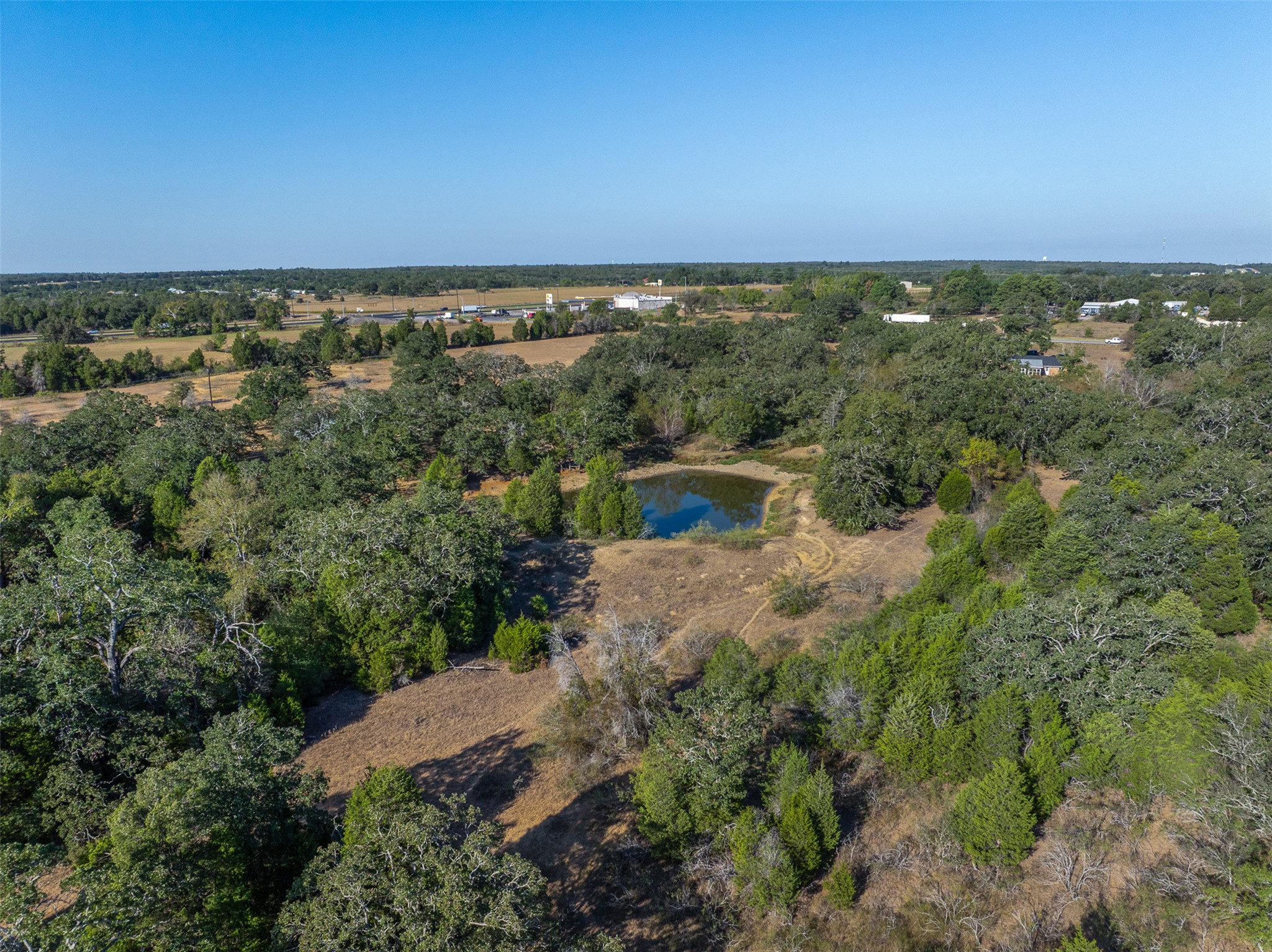 139 Farm To Market 696 Elgin, TX 78621 - Photo 4 of 27 View of property location with a nearby body of water and a tree filled landscape
